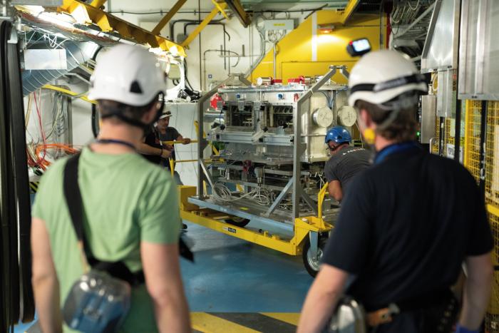 Two men facing away looking at equipment