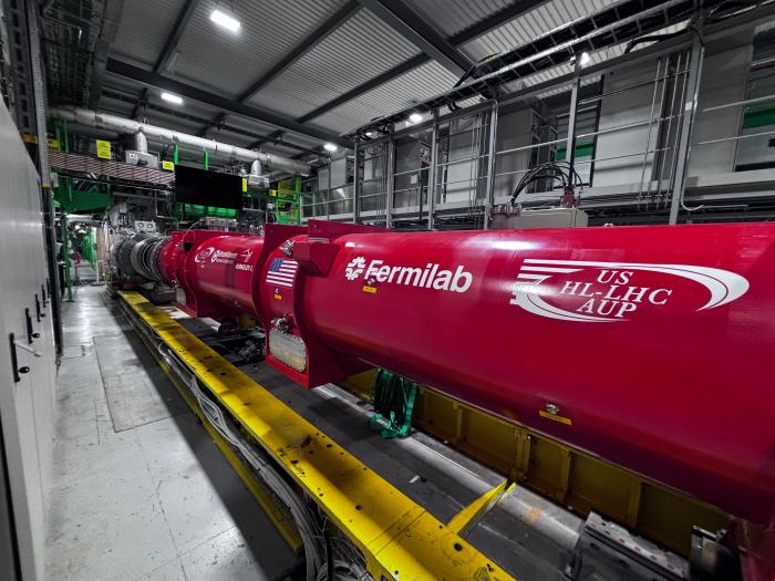  cylindrical red piece of equipment with four white logos on it